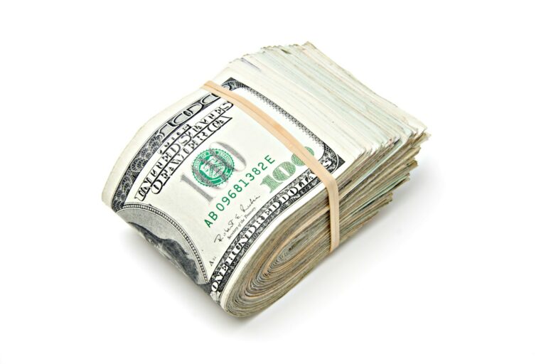 a stack of one hundred dollar bills tied with a string